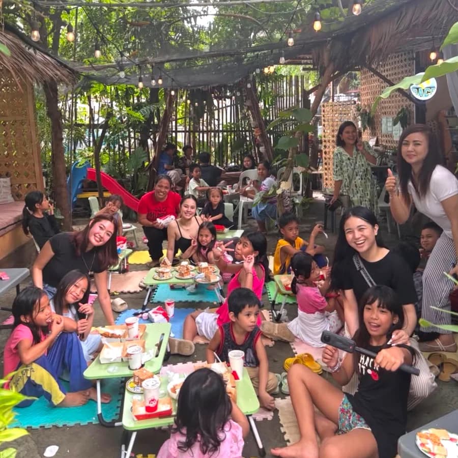 May Bukas Pa volunteers and children sharing a meal outdoors